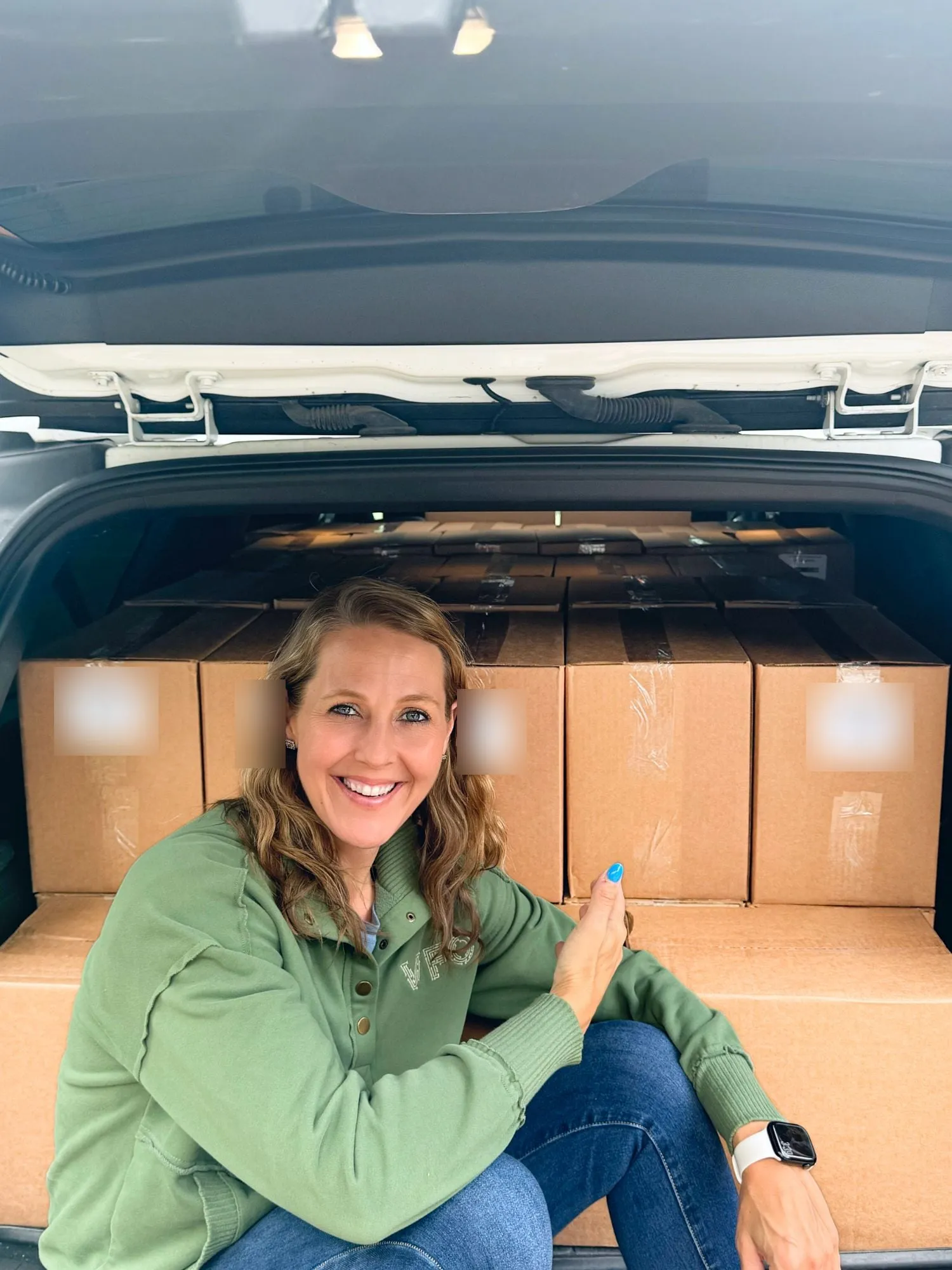 A VFO team member smiling beside a vehicle loaded with sealed boxes of completed petitions.